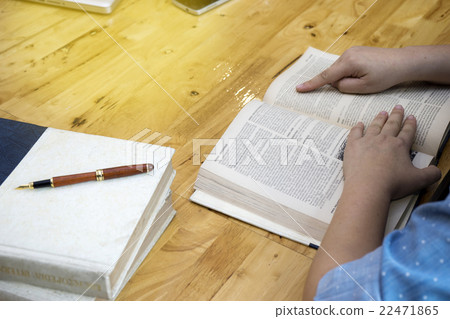 Woman read book on wood table 22471865