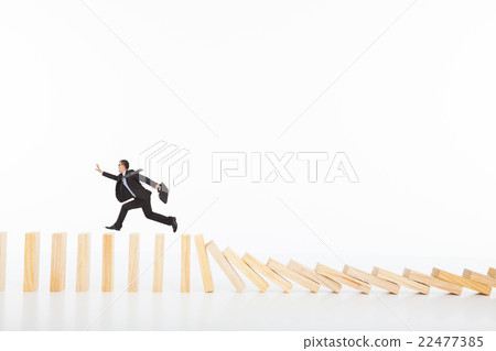 businessman running and catching  on toppling dominoes 22477385