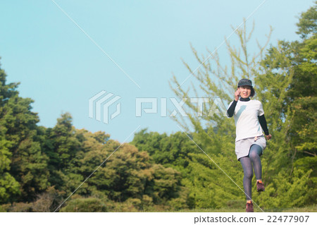 一個女人在新鮮的綠色慢跑 一個女人在新鮮的綠色慢跑 22477907