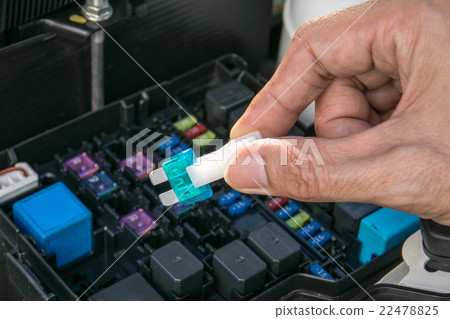 Auto mechanic checking a car fuse Auto mechanic checking a car fuse 22478825