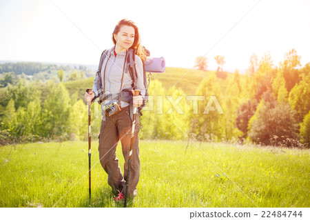Young hiker woman with backpack walking on hills Young hiker woman with backpack walking on hills 22484744