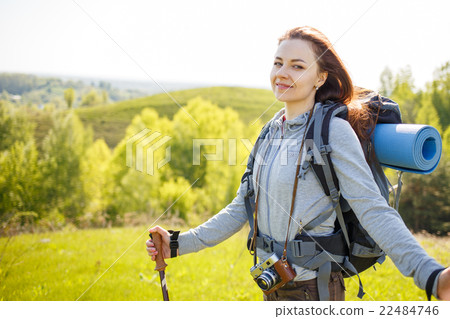 Young hiker woman with backpack standing on hill Young hiker woman with backpack standing on hill 22484746