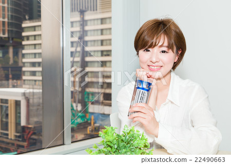 A woman drinking water with a tumbler 22490663