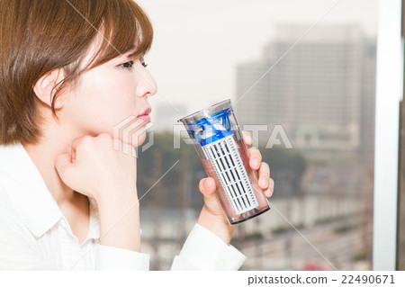 A woman drinking water with a tumbler A woman drinking water with a tumbler 22490671