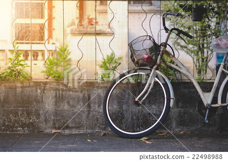 Old bicycle leaning against grunge concrete wall Old bicycle leaning against grunge concrete wall 22498988