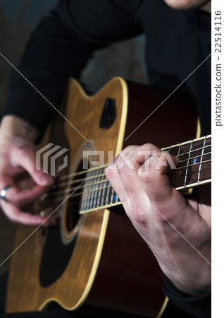 Young man playing on acoustic guitar 22514116