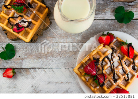 Belgium waffles with strawberries and chocolate.  22515881