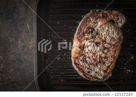 Grilled Ribeye steak on a black frying pan Grilled Ribeye steak on a black frying pan 22517283