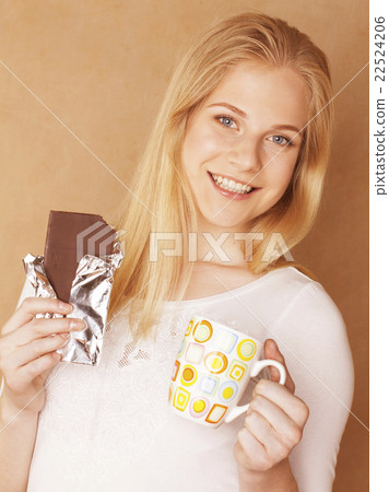 young cute blond girl eating chocolate and 22524206