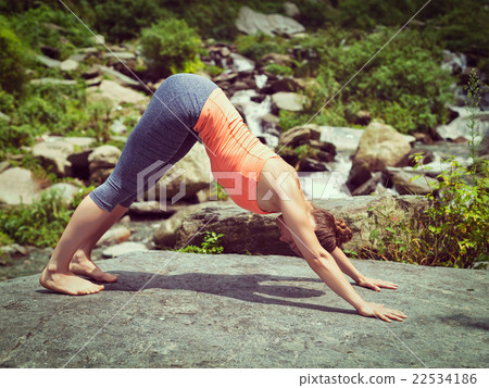 Young sporty fit woman doing yoga oudoors at 22534186