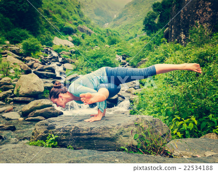 Young sporty fit woman doing yoga oudoors at 22534188