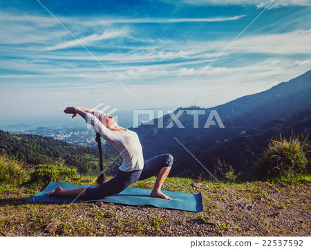 Sporty fit woman practices yoga Anjaneyasana in 22537592