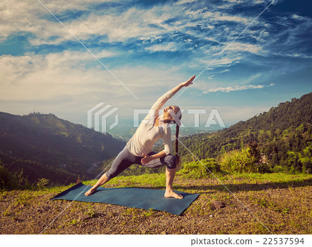 Woman practices yoga asana Utthita Parsvakonasana 22537594