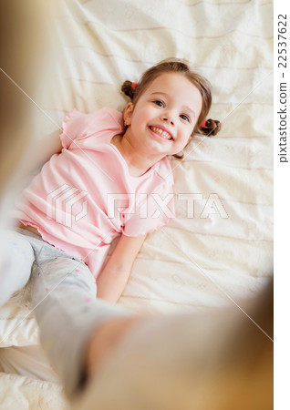 Cute little girl in bedroom jumping on a bed 22537622