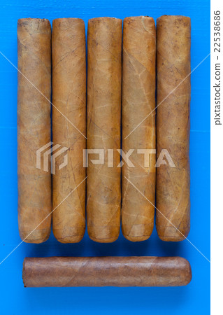 Detail of luxury Cuban cigars on the blue desk Detail of luxury Cuban cigars on the blue desk 22538686