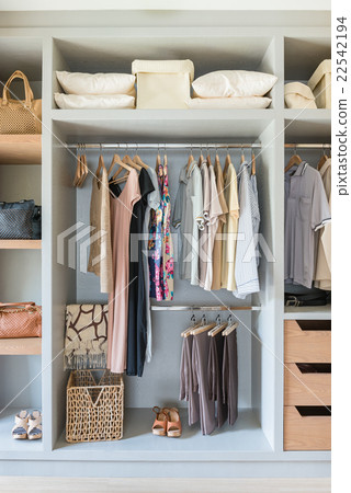 white wardrobe with shirts and pants hanging 22542194