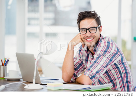 Young man sitting at his desk 22551788