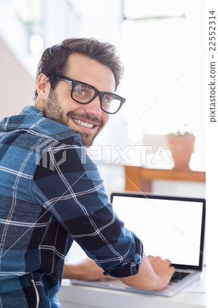 Happy young man using laptop at home 22552314