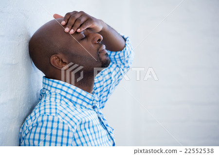 Upset man with eyes closed and hand on the forehead leaning agai Upset man with eyes closed and hand on the forehead leaning agai 22552538