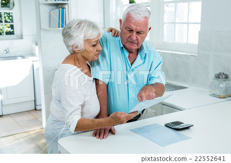 Senior couple holding document at home 22552641