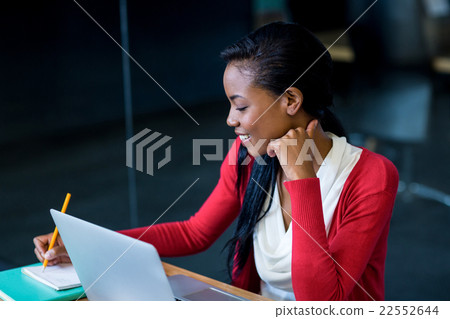 Young woman sitting at her desk Young woman sitting at her desk 22552644