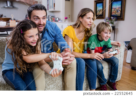 Family sitting on sofa and playing video game 22552645