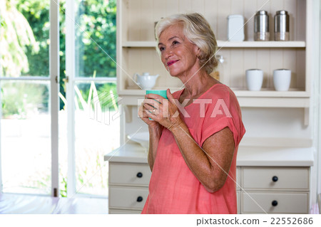 Smiling senior woman having coffee in kitchen 22552686