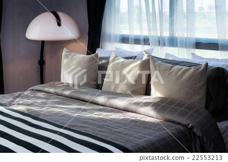 modern bedroom with pillows and white lamp 22553213