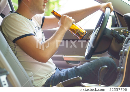 Man drinking beer while driving the car. 22557796