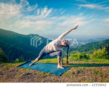 Woman practices yoga asana Utthita Parsvakonasana Woman practices yoga asana Utthita Parsvakonasana 22559842