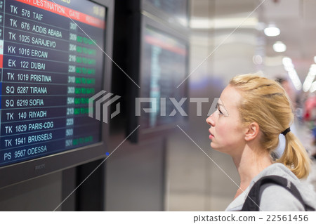 Passenger looking at flight information board. Passenger looking at flight information board. 22561456