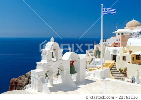White bell tower and Greek flag in Oia. 22563110
