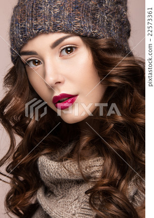 Beautiful girl with curls in brown knit hat. 22573361