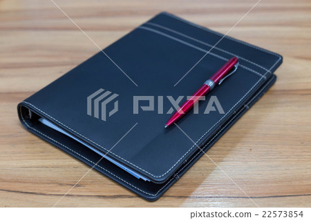Closed notebook on wood table 22573854