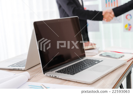 Business people shaking hands over laptop 22593063