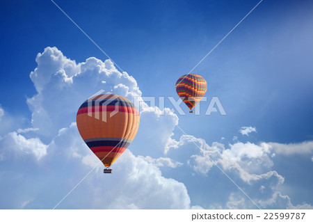 Hot air balloons flies in blue sky 22599787