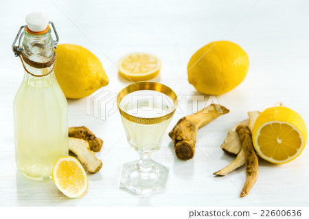 Home ginger tincture in a glass and fresh lemons Home ginger tincture in a glass and fresh lemons 22600636