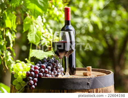Red wine and glass on wodden barrel. 22604198