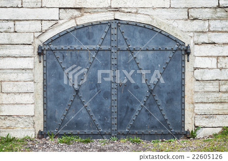 Closed blue metal gate in stone wall Closed blue metal gate in stone wall 22605126