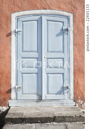 Grungy gray wooden door in old stone wall 22605133