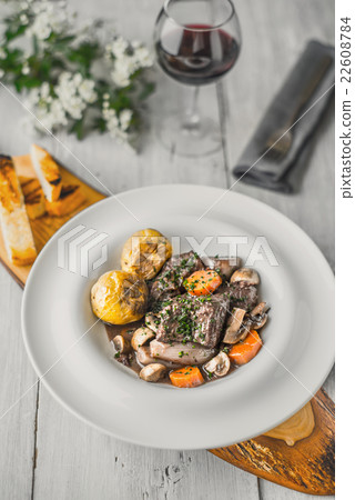 Beef bourguignon in a ceramic dish on a stand 22608784