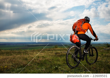 Young man cycling on a rural road through green Young man cycling on a rural road through green 22609501