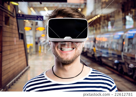 Man wearing virtual reality goggles standing at Man wearing virtual reality goggles standing at 22612781