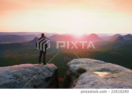 Hiker with sporty backpack on rocky view point 22618260