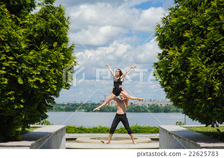 Man lifting woman above head, outdoors 22625783
