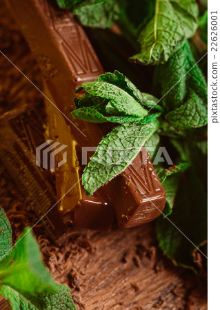 stack of chocolate pieces with a leaf of mint stack of chocolate pieces with a leaf of mint 22626001