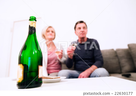 Senior couple sitting in living room , drinking Senior couple sitting in living room , drinking 22630177