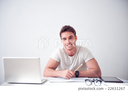 Cheerful smiling  man sitting at the table  22631267