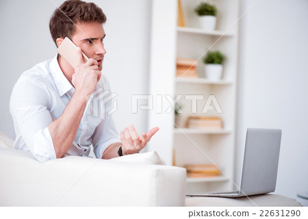 Emotional handsome man talking on cell phone  22631290