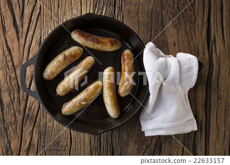 Butchers sausages in a frying pan. Butchers sausages in a frying pan. 22633157